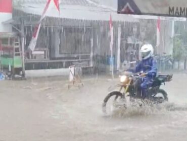 Pemotor melintasi jalan yang tergenang banjir di Senduro, Lumajang. (Foto: tangkapan layar.)