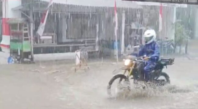 Pemotor melintasi jalan yang tergenang banjir di Senduro, Lumajang. (Foto: tangkapan layar.)