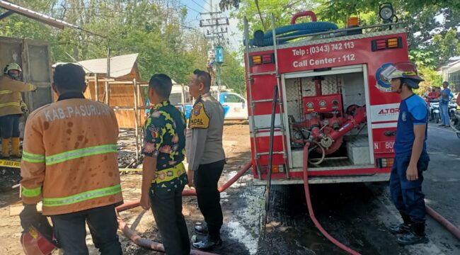 Petugas damkar berjibaku memadamkan api yang melalap deretan kios di Pasar Grati.