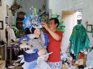 Mahdi, perajin sekaligus penyedia jasa persewaan kostum karnaval di Pasuruan, tengah menyiapkan busana.