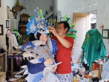 Mahdi, perajin sekaligus penyedia jasa persewaan kostum karnaval di Pasuruan, tengah menyiapkan busana.
