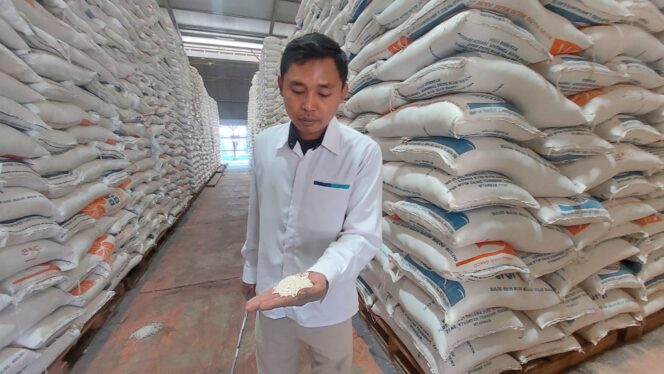
					CEK: Petugas Gudang Bulog Probolinggo saat menunjukkan beras di dalam gudang. (foto: Hafiz Rozani).
