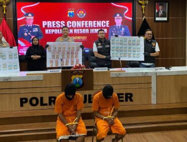 TERSANGKA: Dua tersangka peredaran uang palsu diamankan Polres Jember beserta barang bukti lembaran uang palsu. (Foto: M. Abd Rozaq Mubarok).
