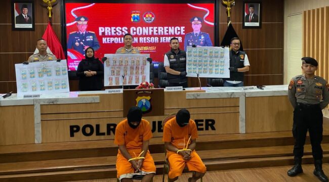 TERSANGKA: Dua tersangka peredaran uang palsu diamankan Polres Jember beserta barang bukti lembaran uang palsu. (Foto: M. Abd Rozaq Mubarok).