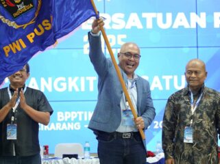 TERPILIH: Akhmad Munir (mengibarkan pataka) usai terpilih sebagai ketua umum PWI Pusat dalam kongres PWI di Gedung BPPTIK Kementerian Komunikasi dan Digital (Kemkomdigi), Cikarang, Bekasi, Jawa Barat. (foto: istimewa)