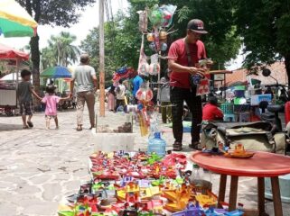 JUALAN: Pedagang kaki lima di Alun-alun Lumajang masih tetap berjualan meski tengah ada proyek perbaikan kawasan. (foto: Asmadi).