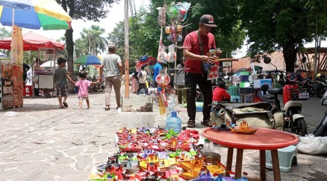JUALAN: Pedagang kaki lima di Alun-alun Lumajang masih tetap berjualan meski tengah ada proyek perbaikan kawasan. (foto: Asmadi).