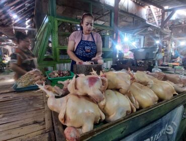 MAHAL: Penjual daging ayam potong di Pasar Baru Kota Probolinggo, Murdiana sedang memotong daging ayam jualannya. (foto: Hafiz Rozani).