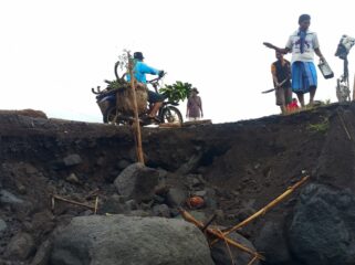 Warga bergotong royong memperbaiki jalan yang rusak di sekitar aliran Sungai Regoyo. (Foto: Asmadi).