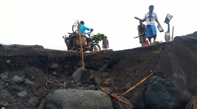 Warga bergotong royong memperbaiki jalan yang rusak di sekitar aliran Sungai Regoyo. (Foto: Asmadi).