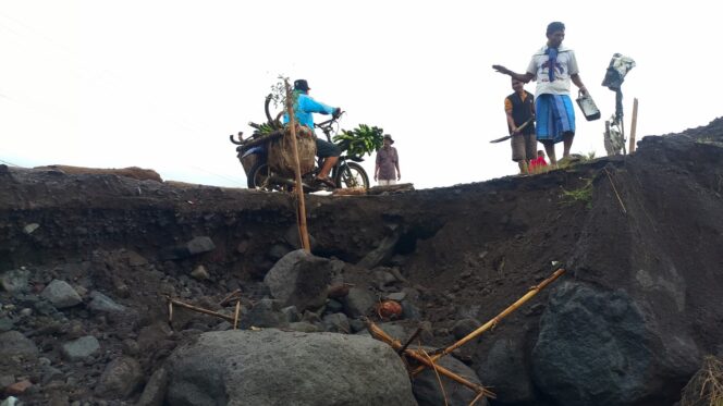 
					Warga bergotong royong memperbaiki jalan yang rusak di sekitar aliran Sungai Regoyo. (Foto: Asmadi).