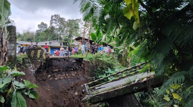 Hujan lebat yang mengguyur Kabupaten Lumajang selama dua hari terakhir menyebabkan jembatan penghubung antara Kecamatan Senduro dan Kecamatan Gucialit di Desa Kandangan, Kecamatan Senduro ambrol. (Foto: Asmadi).