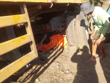 TERLINDAS: Korban (tertutup kain warna oranye) berada dibawah kolong truk di Jalan Raya Tongas Probolinggo. (foto: Hafiz Rozani).