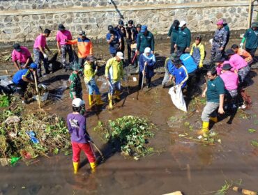TURUN: Khofifah Indar Pawaransa, Gubernur Jawa Timur (berkerudung biru) saat terjun ke sungai Legundi Probolinggo untuk membersihkan sampah. (foto: Hafiz Rozani).
