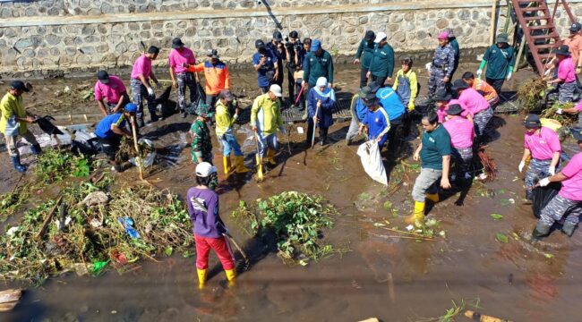 TURUN: Khofifah Indar Pawaransa, Gubernur Jawa Timur (berkerudung biru) saat terjun ke sungai Legundi Probolinggo untuk membersihkan sampah. (foto: Hafiz Rozani).
