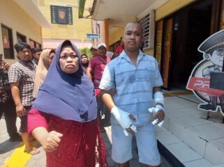 PROTES: Muhammad Andre (kedua tangan dibalut perban) saat mendatangi Polres Probolinggo Kota untuk melayangkan protes. (foto: Hafiz Rozani).
