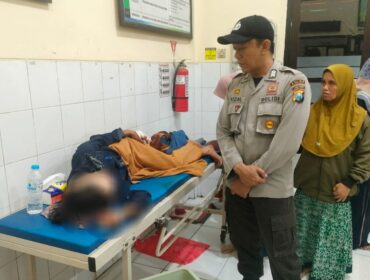 DIRAWAT: Anggota polisi mengawasi kondisi Sofia, korban pembacokan di Desa Pedagangan, Tiris, Probolinggo. (Foto: istimewa)