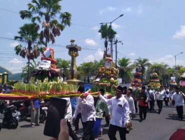MERIAH: Warga membawa gunungan hasil bumi untuk disedekahkan kepada masyarakat setelah didoakan bersama, di Alun-alun Kota Jember. (Foto: M. Abd Rozaq Mubarok).