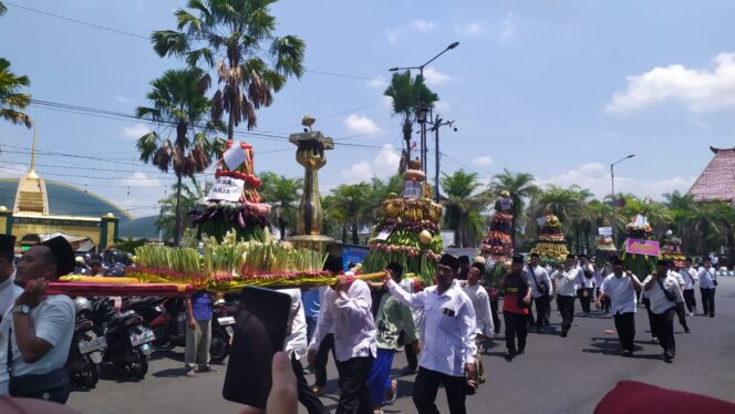 
					MERIAH: Warga membawa gunungan hasil bumi untuk disedekahkan kepada masyarakat setelah didoakan bersama, di Alun-alun Kota Jember. (Foto: M. Abd Rozaq Mubarok).