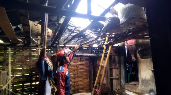 Petugas BPBD Kabupaten Pasuruan memeriksa kondisi rumah warga di Dusun Krajan, Desa Petung, Kecamatan Pasrepan, yang atapnya rusak parah usai diterjang angin puting beliung. (Foto: Moh. Rois)