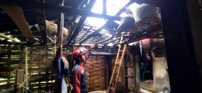 
					Petugas BPBD Kabupaten Pasuruan memeriksa kondisi rumah warga di Dusun Krajan, Desa Petung, Kecamatan Pasrepan, yang atapnya rusak parah usai diterjang angin puting beliung. (Foto: Moh. Rois)