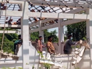 Warga membongkar bangunan makam yang berada di belakang Masjid Serambi, Desa Winongan Kidul, Kecamatan Winongan, Kabupaten Pasuruan. (Foto: Moh. Rois)