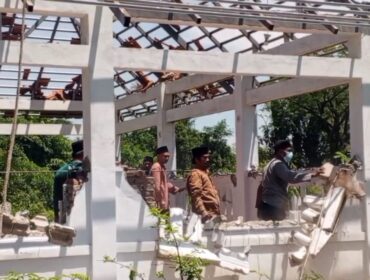 Warga membongkar bangunan makam yang berada di belakang Masjid Serambi, Desa Winongan Kidul, Kecamatan Winongan, Kabupaten Pasuruan. (Foto: Moh. Rois)