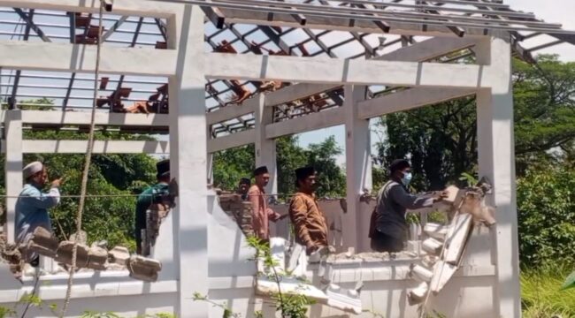 Warga membongkar bangunan makam yang berada di belakang Masjid Serambi, Desa Winongan Kidul, Kecamatan Winongan, Kabupaten Pasuruan. (Foto: Moh. Rois)