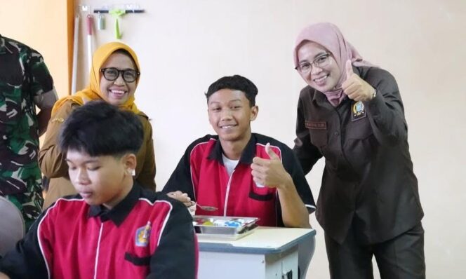 
					AWASI: Ketua DPRD Kabupaten Lumajang, Oktafiyani (acungkan jempol) saat memantau pelaksanaam program MBG di sekolah. (foto: Asmadi).
