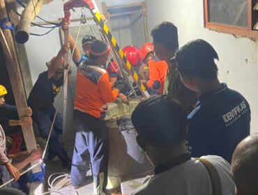 Petugas gabungan saat mengevakuasi jasad korban dari dalam sumur.