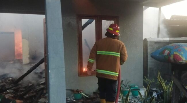 SEMPROT: Petugas Damkar Kabupaten Probolinggo sedang memadamkan api di rumah Suari di Desa Talkadang, Kecamatan Kotaanyar. (foto: Ali Ya'lu).