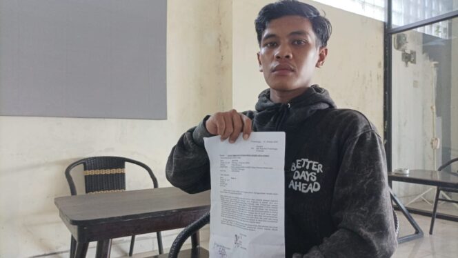 
					KORBAN: Adi menunjukkan bukti laporan kepolisiannya usai motornya dirampas DC yang menggunakam pisau di Alun-alun Kraksaan, Probolinggo. (foto: Ali Ya'lu).
