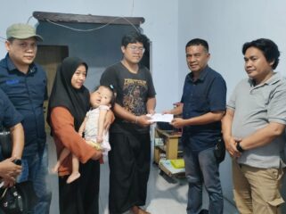 PEDULI: Ketua Pokja Jurnalis Kraksaan Ahmad Taufik (kanan) memberikan bantuan sosial kepada Gilang Ramadhan, ayah dari Elena yang menderita sindrom proteus. (foto: Ali Ya'lu).
