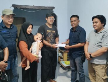 PEDULI: Ketua Pokja Jurnalis Kraksaan Ahmad Taufik (kanan) memberikan bantuan sosial kepada Gilang Ramadhan, ayah dari Elena yang menderita sindrom proteus. (foto: Ali Ya'lu).
