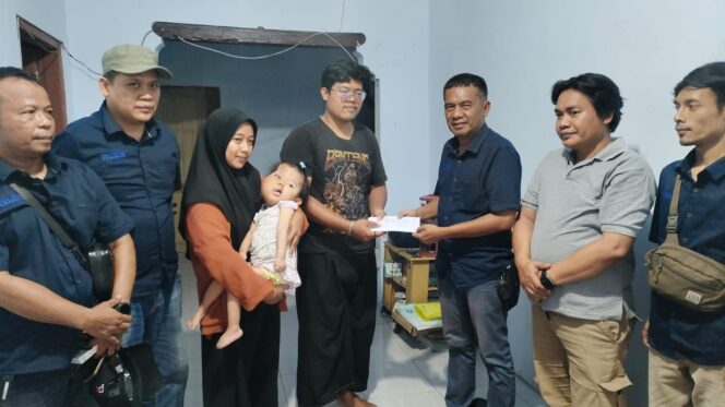 
					PEDULI: Ketua Pokja Jurnalis Kraksaan Ahmad Taufik (kanan) memberikan bantuan sosial kepada Gilang Ramadhan, ayah dari Elena yang menderita sindrom proteus. (foto: Ali Ya'lu).
